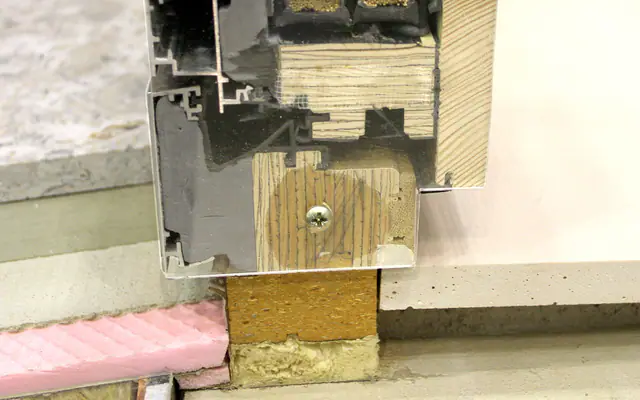 Coupe technique d’une menuiserie associant bois, matériau synthétique et aluminium
